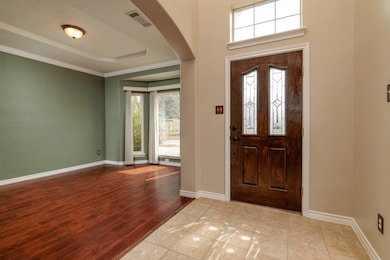 Entryway with arched walkways, a raised ceiling, v