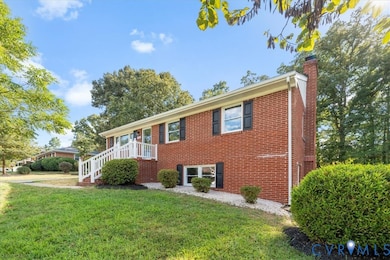View of front of home with a chimney, a front lawn, and brick siding