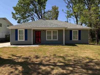 View of front facade featuring roof with shingles, a front yard, and covered porch