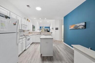 Kitchen featuring white appliances, a kitchen isla