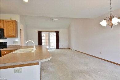 Kitchen featuring vaulted ceiling, light carpet, r