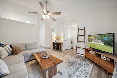Living room featuring lofted ceiling, hardwood / w