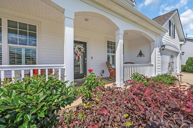 Doorway to property with covered porch, roof with shingles, and a garage