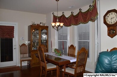 Bay window over looks green space. Curtains remain.