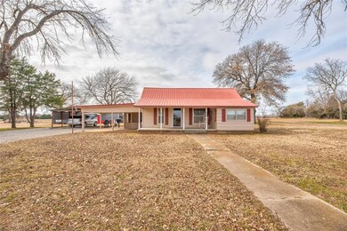 View of front of home with a carport and covered p