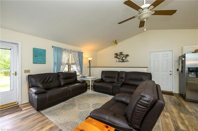 Hardwood floored living room featuring vaulted cei
