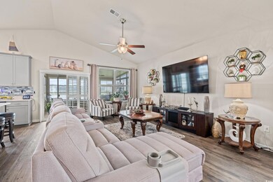 Living room featuring vaulted ceiling, hardwood / 