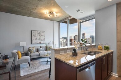 Kitchen featuring dishwasher, dark wood-style floors, light stone countertops, a view of city, and dark brown cabinetry