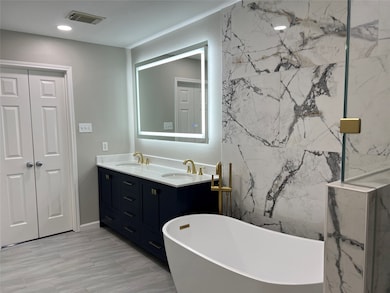 The ensuite primary bath is designed to both relax
