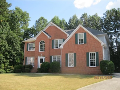 Colonial-style house with a front yard and brick siding