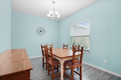 Dining space with wood finished floors and a chandelier