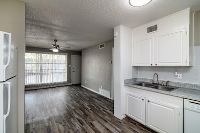 Kitchen featuring a sink, a ceiling fan, white app