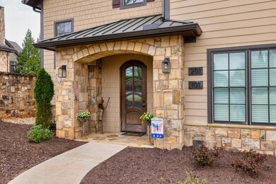 Property entrance with stone siding, metal roof, a