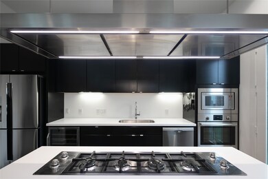 Island cooktop with quartz countertops and stainless steel Bosch and Foster appliances.