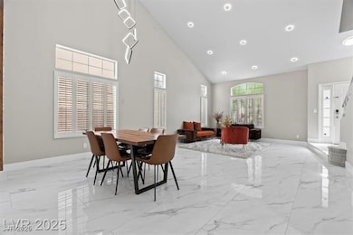 Dining area with high vaulted ceiling, light marble finish floors, recessed lighting, and stairway