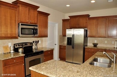 Inviting kitchen features granite countertops, til