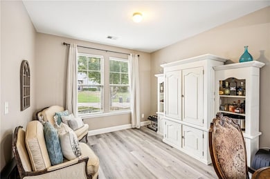 Sitting room featuring light wood-type flooring and baseboards