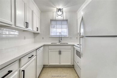 Kitchen with sink, white cabinets, white appliances, and light tile patterned floors