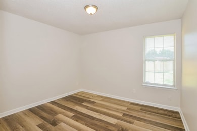 Unfurnished room with healthy amount of natural light and wood finished floors
