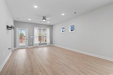 Living/dining/kitchen room with light wood finished floors, recessed lighting, and a ceiling fan