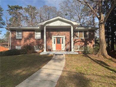 Raised ranch with brick siding and a front yard