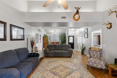 Living room with wood finished floors, a chandelie