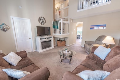 Carpeted living room with a high ceiling