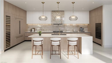 Kitchen featuring modern cabinets, light countertops, a kitchen island with sink, a breakfast bar, and recessed lighting