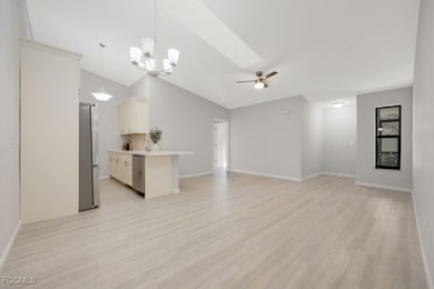 Unfurnished living room with vaulted ceiling, ligh