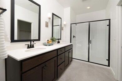 Primary bath with dual sinks and glass shower enclosure