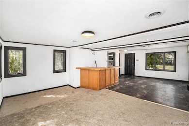 Bar with dark colored carpet, brown cabinetry, beam ceiling, and dark stone finish floors