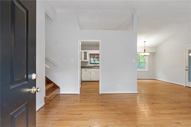 Foyer featuring light wood-style flooring, stairway, and a chandelier