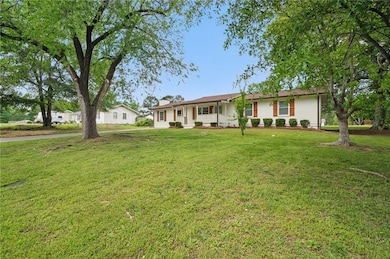 Ranch-style home with covered porch and a front ya