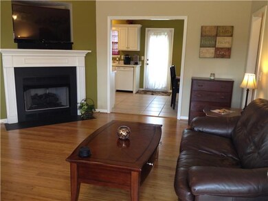 Living room has vaulted ceiling and gas log fireplace.
