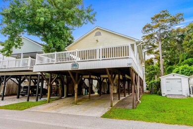 View of front of house featuring a shed, a carport, and a front yard