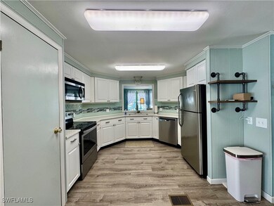 Kitchen featuring white wood-style flooring, appli