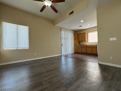 Unfurnished living room featuring ceiling fan, dar