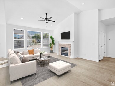 Living area featuring light wood-style flooring, a brick fireplace, recessed lighting, ceiling fan, and high vaulted ceiling