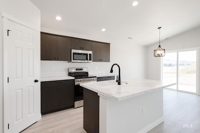 Kitchen with light countertops, appliances with stainless steel finishes, dark brown cabinetry, recessed lighting, and pendant lighting