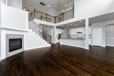Great room includes soaring ceilings and cozy fire