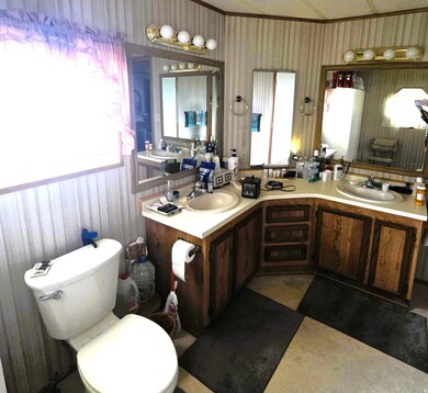 Full bath with double vanity and wallpapered walls