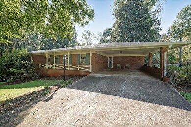 Ranch-style house with driveway, a carport, and brick siding