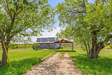 View of yard featuring dirt driveway, fence, a po