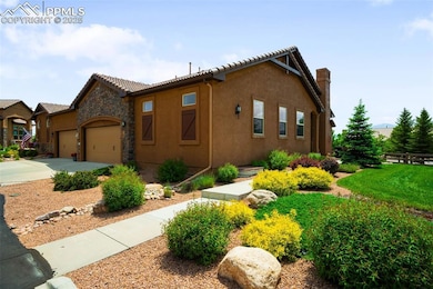 View of front of home featuring an attached garage, stucco siding, concrete driveway, a chimney, and a tile roof