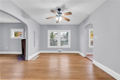 Spare room featuring a fireplace, light hardwood / wood-style floors, and ceiling fan