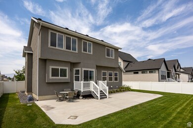 Rear view of property with stucco siding, a fenced backyard, and a patio