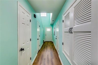 Hallway featuring wood finished floors and baseboa