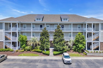 View of apartment building / complex featuring uncovered parking