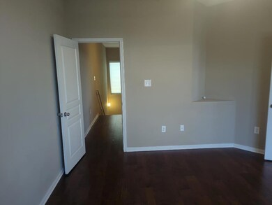Empty room with dark wood-style floors and baseboards