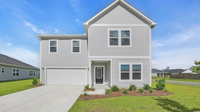 Traditional-style home with a front lawn, an attached garage, and driveway